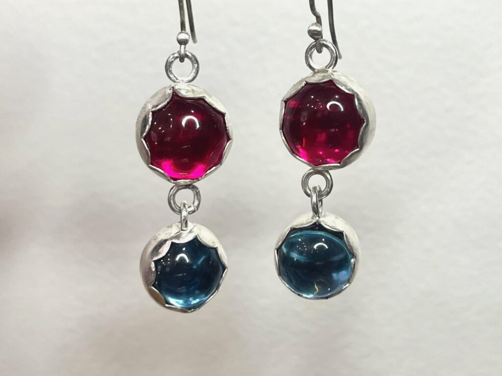 dangling silver earrings with bright pink and blue glass cabochons