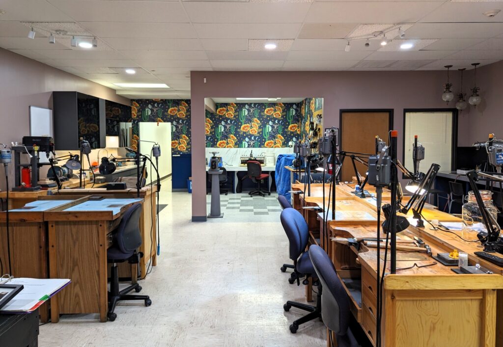 Image of the Jeweler's Saw studio space featuring benches equipped with flex shafts, various specialized tools including rolling mill, buffing machine, lapidary machines, soldering stations